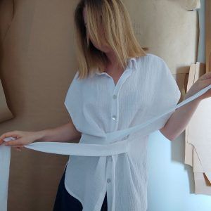 Ljetna bijela oversized pamučna bluza od 100% prirodne tetra tkanine sa skrivenim kopčanjem, spuštenim ramenima i kratkim rukavima.
